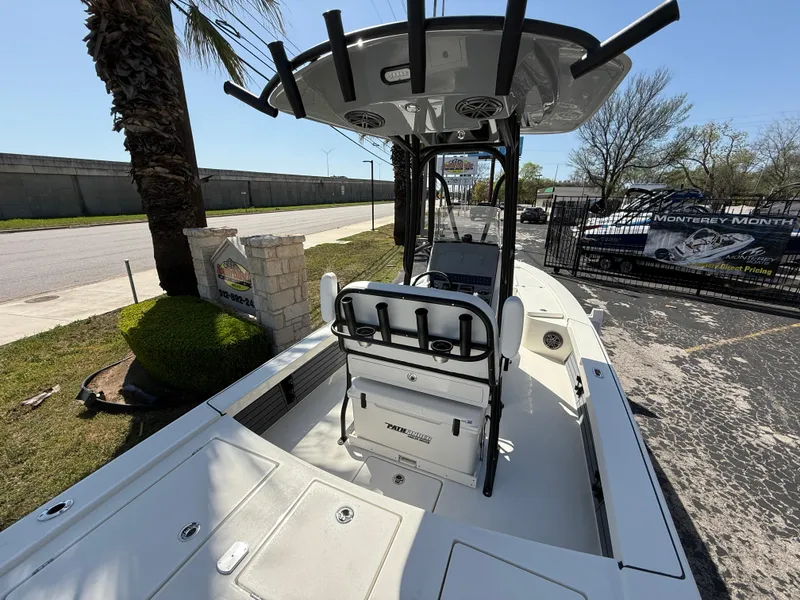 Slide: The Image of 2025 Pathfinder 2300 HPS boat with T-top, parked outdoors on a sunny day. - 17