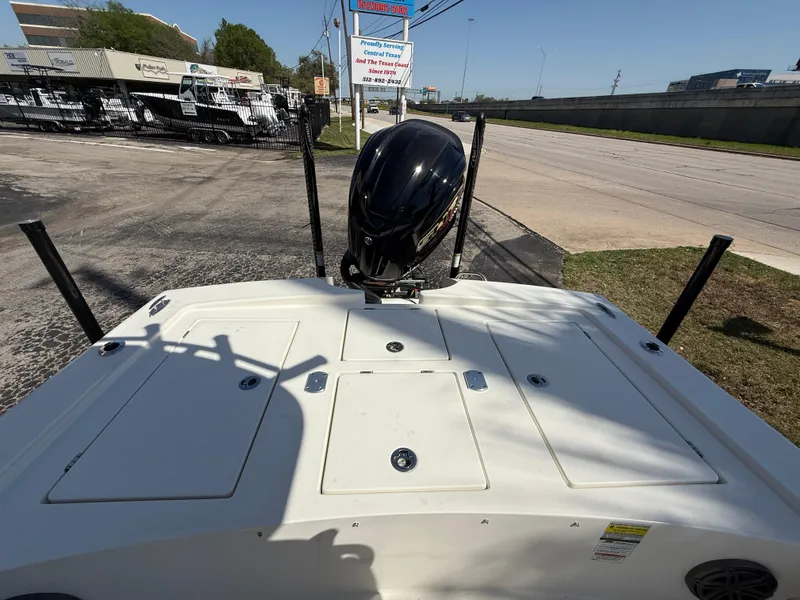 Slide: The Image of 2025 Pathfinder 2300 HPS boat with outboard motor, parked near a road. - 19