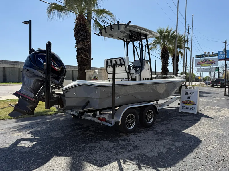 Slide: The Image of 2025 Pathfinder 2300 HPS boat on trailer, parked outdoors near palm trees. - 6
