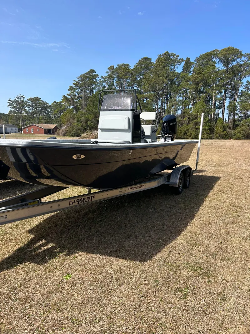 Slide: The Image of 2022 May-Craft 25 Hancock Edition boat on trailer, parked on grass with trees in background. - 3