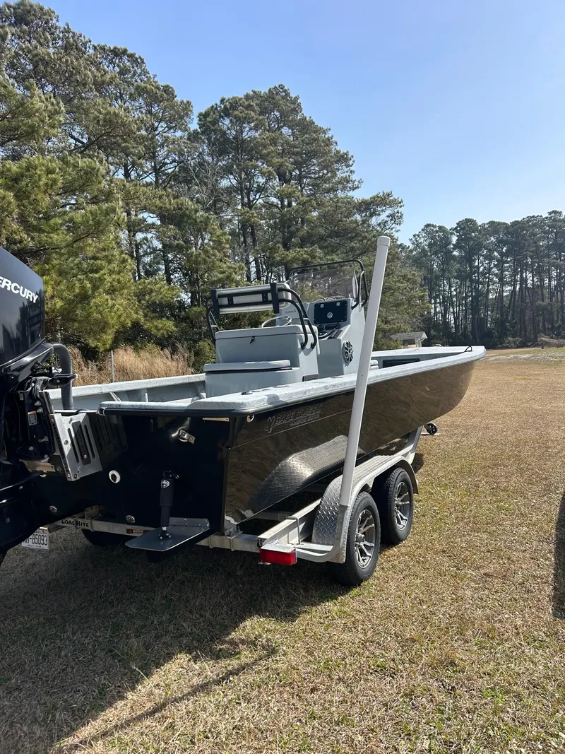 Slide: The Image of 2022 May-Craft 25 Hancock Edition boat on trailer, parked on grass with trees in background. - 6