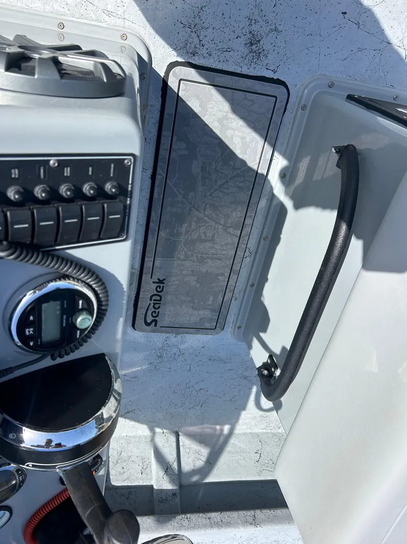 Slide: The Image of 2022 May-Craft 25 Hancock Edition boat console with controls and SeaDek flooring. - 9