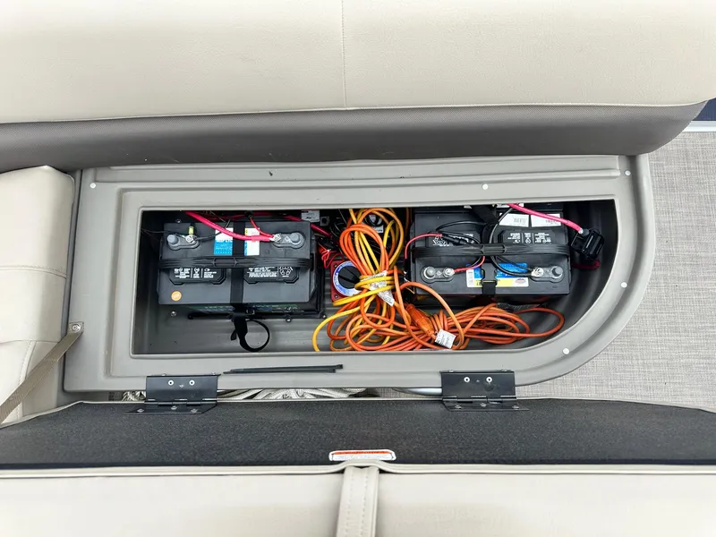 Slide: The Image of 2023 Sun Tracker Bass Buggy 16 XL Select battery compartment with wiring and storage. - 16