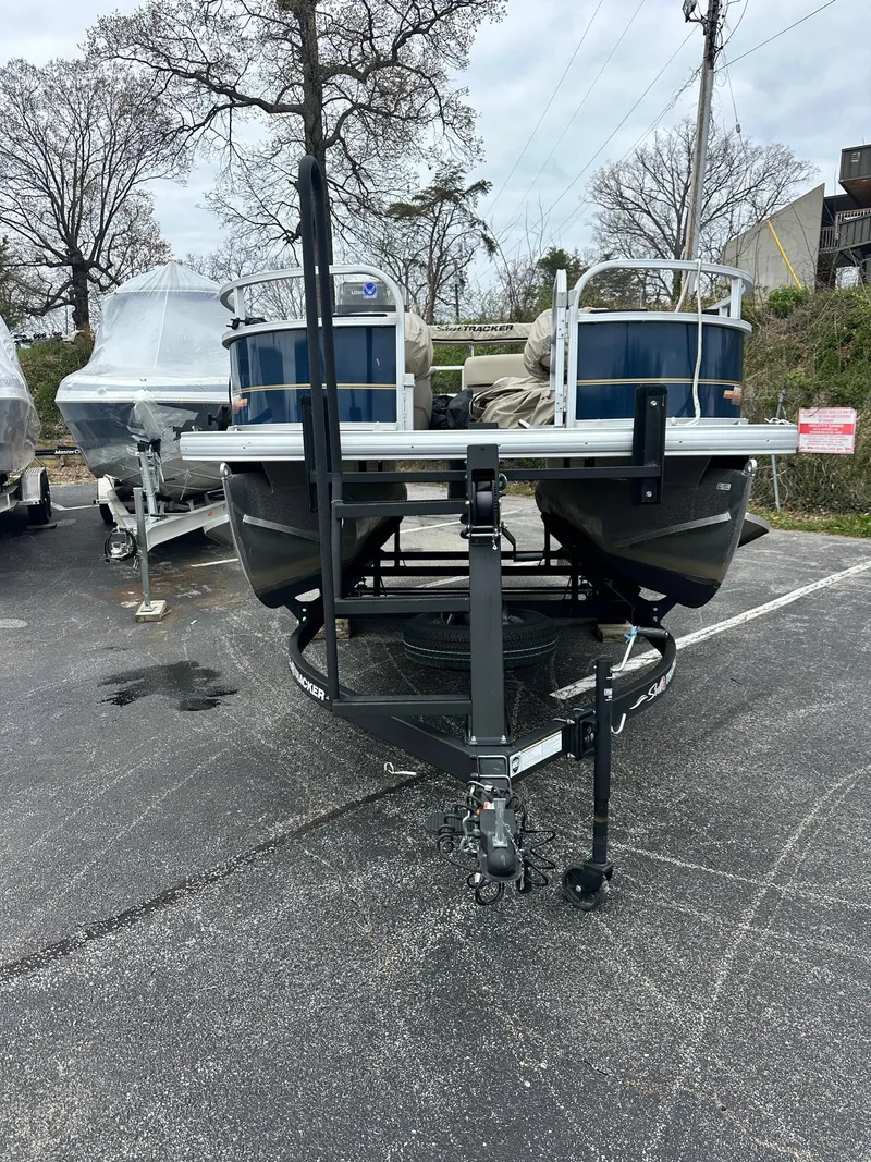 Slide: The Image of 2023 Sun Tracker Bass Buggy 16 XL Select pontoon boat in a parking lot. - 22