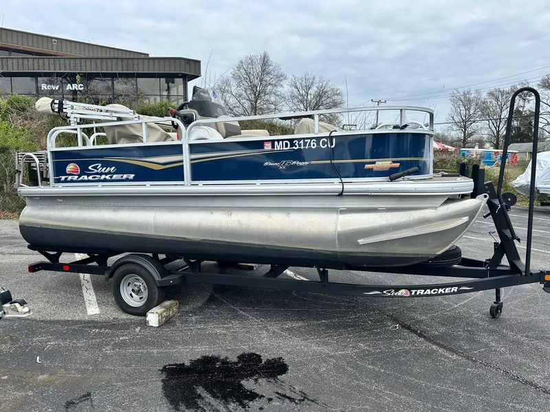 Slide: The Image of 2023 Sun Tracker Bass Buggy 16 XL Select pontoon boat on trailer in parking lot. - 3