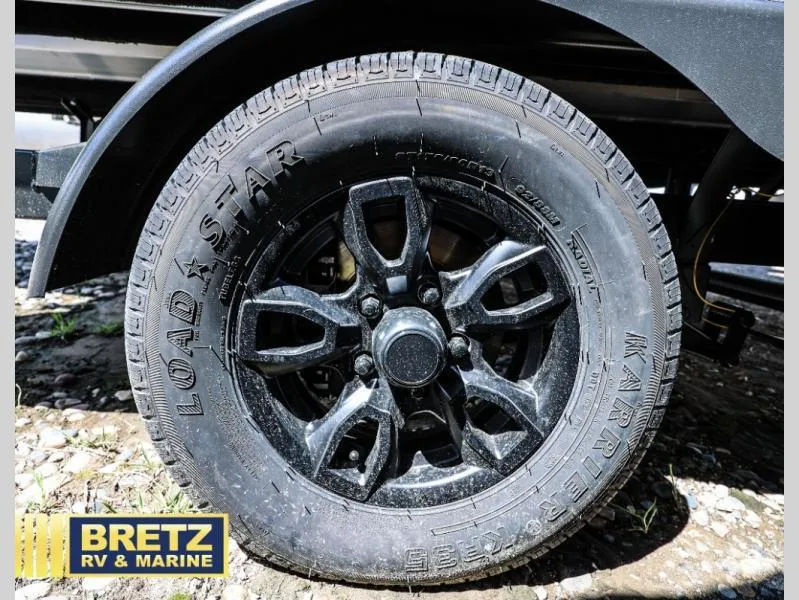 Slide: The Image of Black wheel of Aria Ultra-Lounge A22UC 2025 with Load Star tire, Bretz RV & Marine logo. - 23