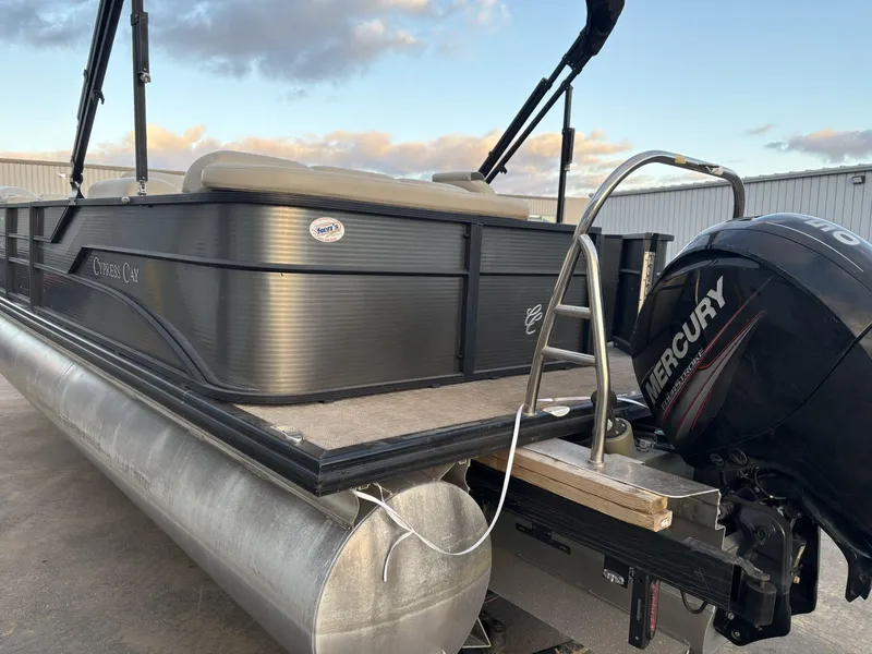 Slide: The Image of 2018 Cypress Cay Seabreeze 233 pontoon boat with Mercury outboard motor, docked under cloudy sky. - 11