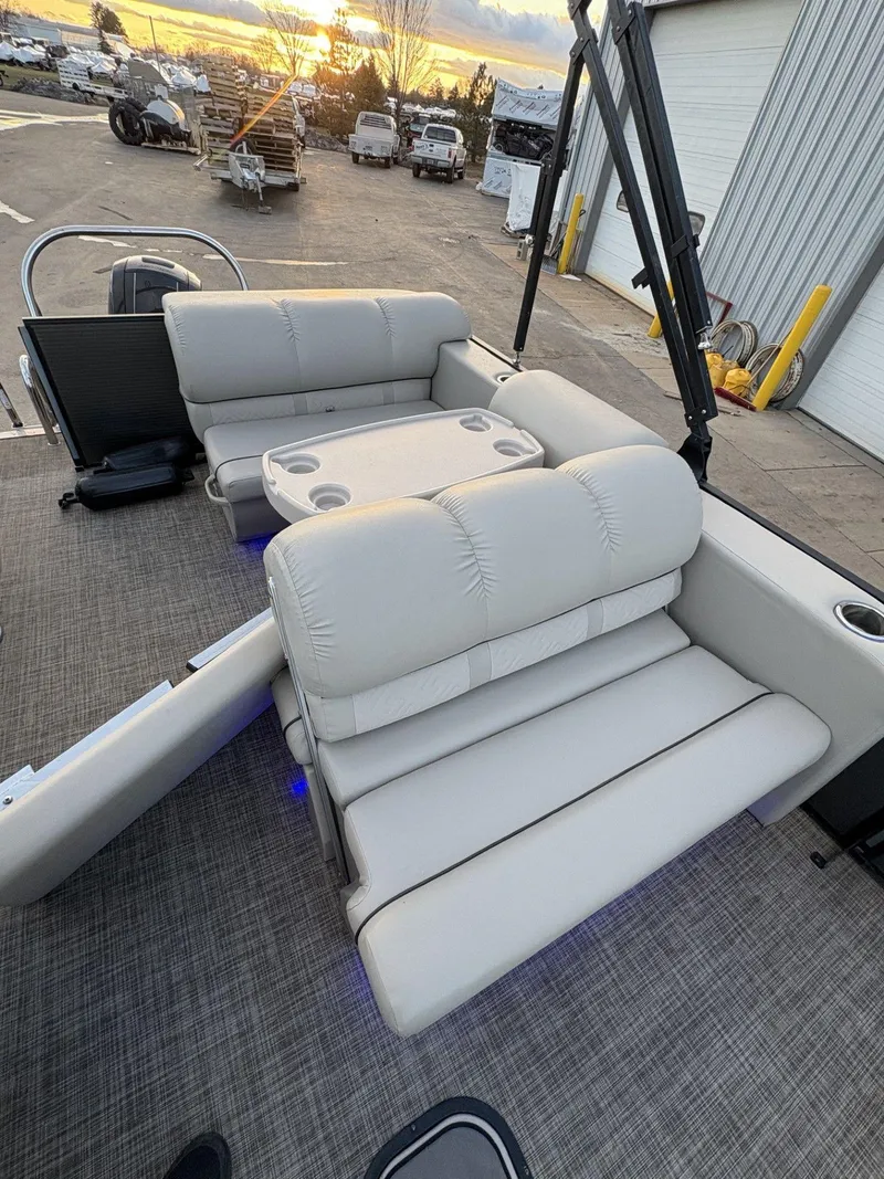 Slide: The Image of 2018 Cypress Cay Seabreeze 233 boat interior with plush seating and cup holders at sunset. - 22
