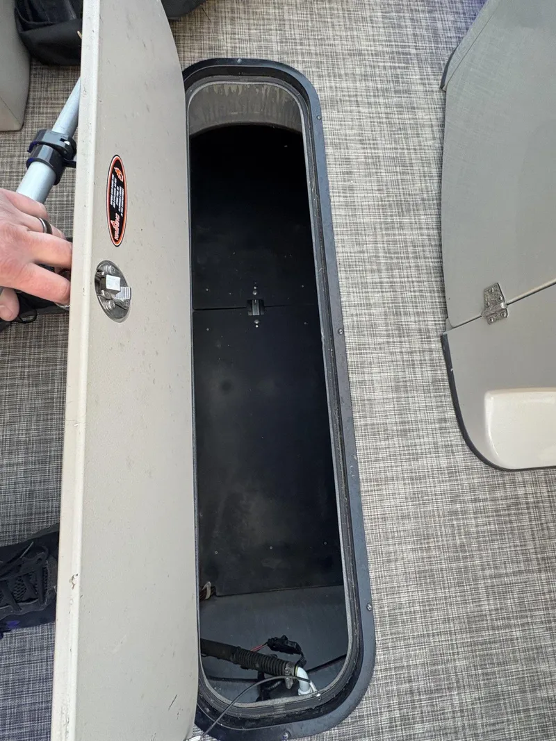 Slide: The Image of Open storage compartment on 2018 Cypress Cay Seabreeze 233 boat, showing interior space. - 25
