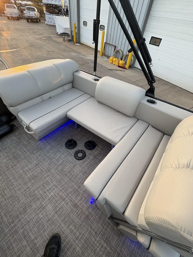 Slide: The Image of 2018 Cypress Cay Seabreeze 233 boat interior with beige seating and blue LED lighting. - 26