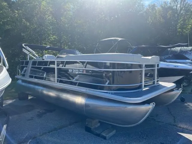 Slide: The Image of 2023 Starcraft EX 20C pontoon boat parked outdoors in sunlight. - 1