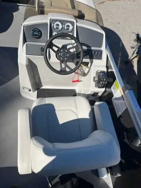 Slide: The Image of 2023 Starcraft EX 20C boat helm with steering wheel and captain's chair. - 10