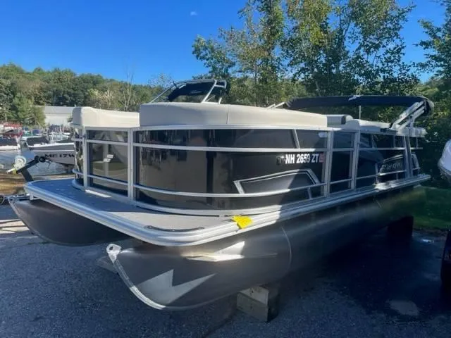 Slide: The Image of 2023 Starcraft EX 20C pontoon boat parked outdoors on a sunny day. - 2