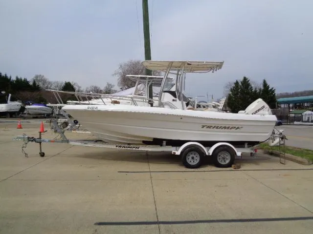 Slide: The Image of 2008 Triumph 215 CC boat on trailer, parked outdoors, side view. - 0