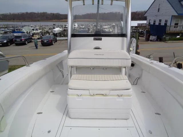Slide: The Image of 2008 Triumph 215 CC boat interior with seating and storage, docked near marina. - 11