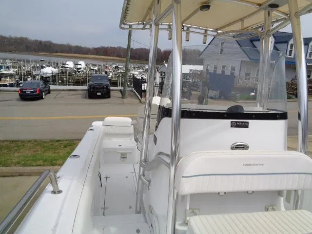 Slide: The Image of 2008 Triumph 215 CC boat docked near marina with houses and parked cars in background. - 15