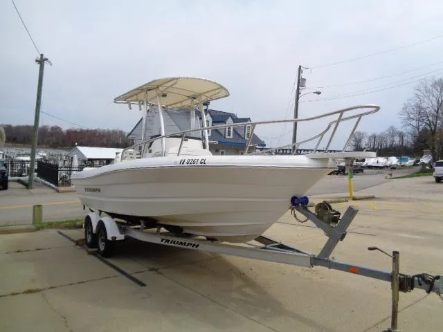 Slide: The Image of 2008 Triumph 215 CC boat on trailer in a parking lot. - 2