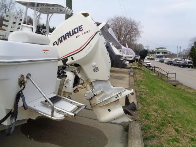 Slide: The Image of 2008 Triumph 215 CC boat with Evinrude E-TEC outboard motor, parked on a roadside. - 3