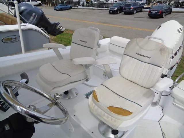 Slide: The Image of 2008 Triumph 215 CC boat interior with worn white seats and steering wheel. - 9