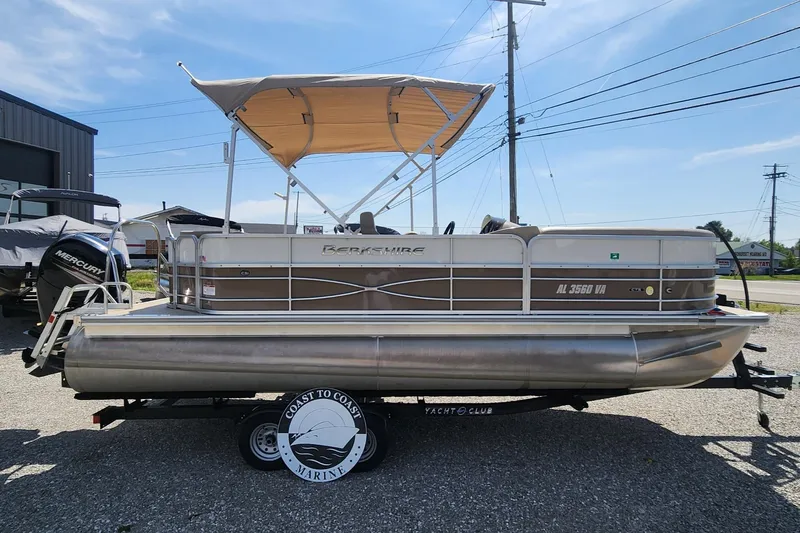 Slide: The Image of 2018 Berkshire 22CL CTS pontoon boat on trailer, beige canopy, parked outdoors. - 1