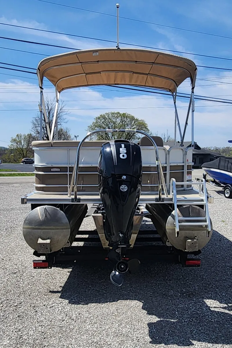 Slide: The Image of 2018 Berkshire 22CL CTS pontoon boat with canopy and outboard motor, parked on gravel. - 3