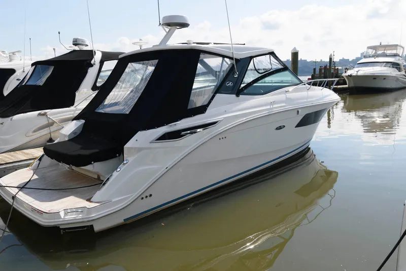 Slide: The Image of 2020 Sea Ray Sundancer 320 yacht docked in marina, featuring sleek design and black canopy. - 0