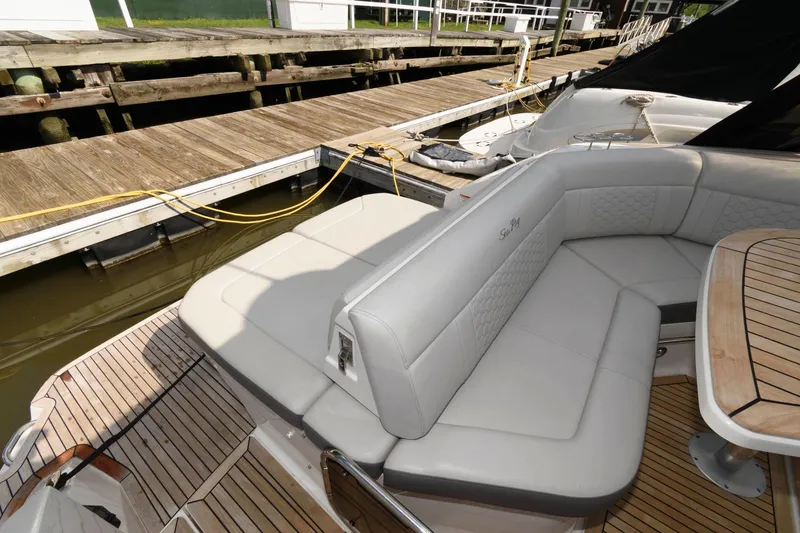 Slide: The Image of 2020 Sea Ray Sundancer 320 boat with cushioned seating and wooden deck at dock. - 12