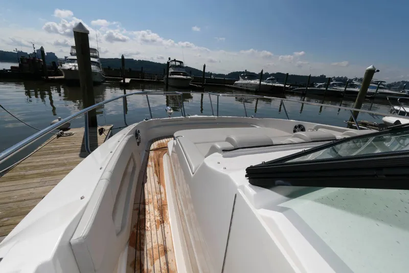 Slide: The Image of 2020 Sea Ray Sundancer 320 docked at marina, showcasing spacious deck and sleek design. - 16