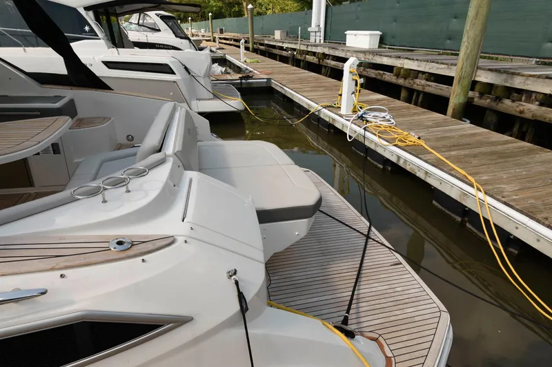 Slide: The Image of 2020 Sea Ray Sundancer 320 docked, showcasing sleek design and spacious deck area. - 17