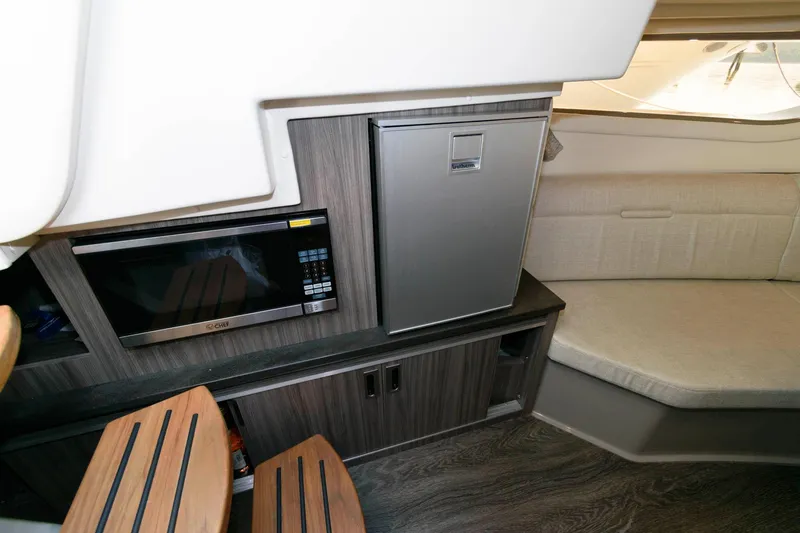 Slide: The Image of 2020 Sea Ray Sundancer 320 interior with microwave, fridge, and seating area. - 20