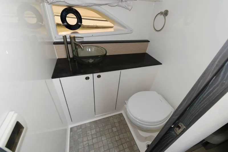 Slide: The Image of 2020 Sea Ray Sundancer 320 bathroom with modern sink, toilet, and porthole window. - 21