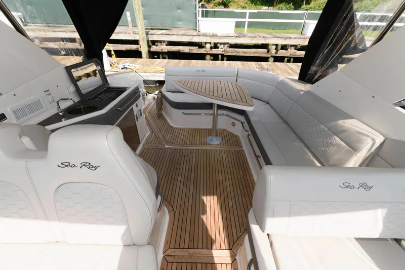 Slide: The Image of 2020 Sea Ray Sundancer 320 interior with white seating, wooden flooring, and a compact dining area. - 4