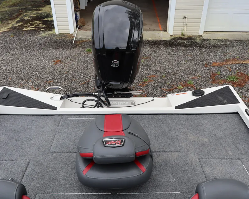 Slide: The Image of 2022 Ranger RT178 boat with motor and seating, parked on gravel near a garage. - 10