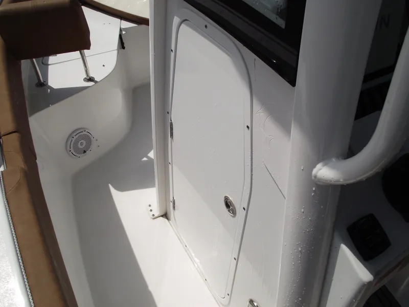Slide: The Image of 2024 Sea Hunt Ultra 239 SE boat interior with white door and seating area. - 16