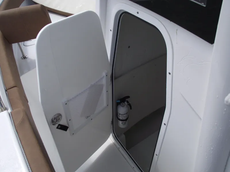 Slide: The Image of 2024 Sea Hunt Ultra 239 SE boat interior storage compartment with fire extinguisher. - 17