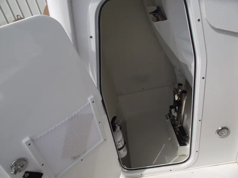 Slide: The Image of 2024 Sea Hunt Ultra 239 SE boat interior storage compartment with open door. - 18
