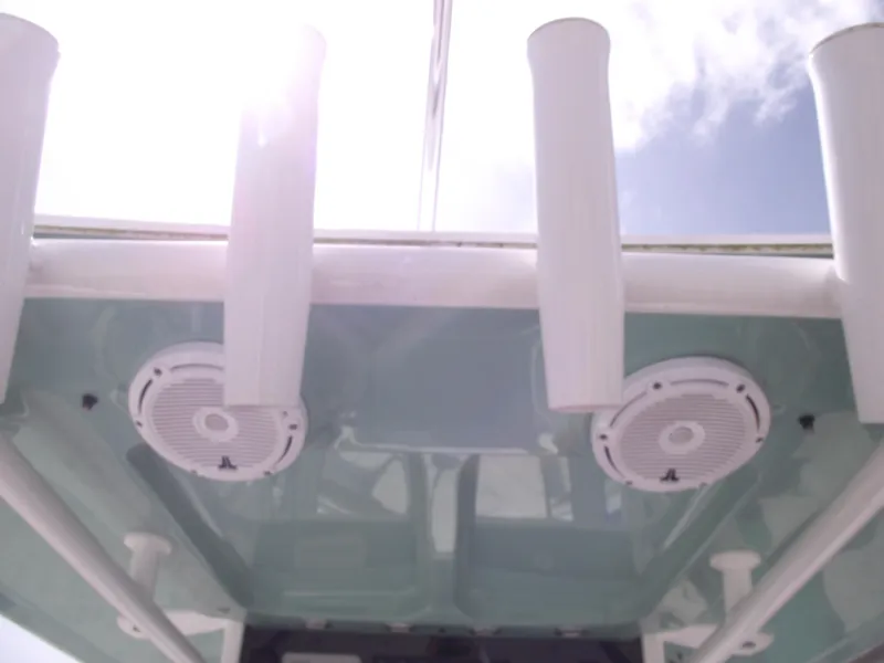 Slide: The Image of 2024 Sea Hunt Ultra 239 SE boat speakers and rod holders under a sunny sky. - 22