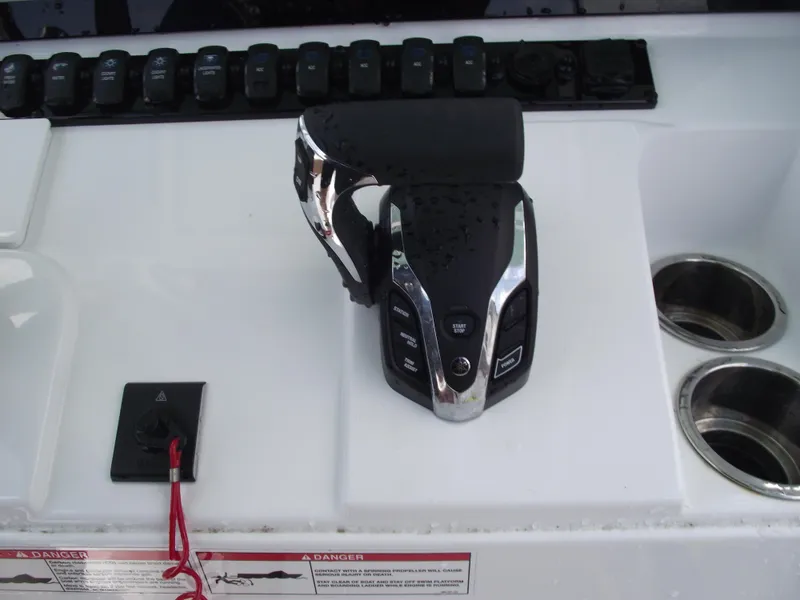 Slide: The Image of 2024 Sea Hunt Ultra 239 SE boat control panel with throttle and switches. - 26