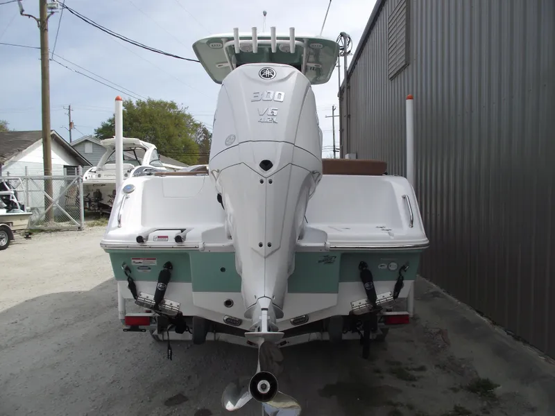 Slide: The Image of 2024 Sea Hunt Ultra 239 SE boat with powerful outboard motor, docked outdoors. - 3