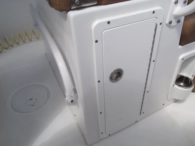 Slide: The Image of 2024 Sea Hunt Ultra 239 SE boat storage compartment with secure latch and cup holder. - 33