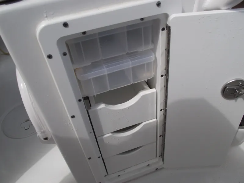 Slide: The Image of 2024 Sea Hunt Ultra 239 SE storage compartment with drawers and tackle boxes. - 34