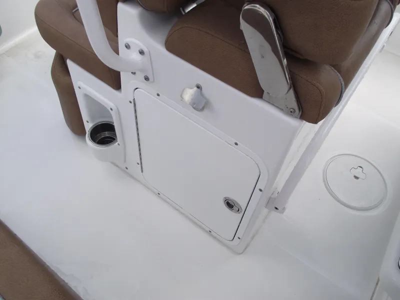 Slide: The Image of 2024 Sea Hunt Ultra 239 SE boat interior with brown seating and storage compartment. - 36