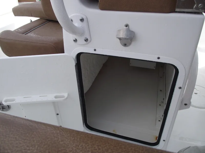 Slide: The Image of 2024 Sea Hunt Ultra 239 SE boat storage compartment with brown seating. - 38