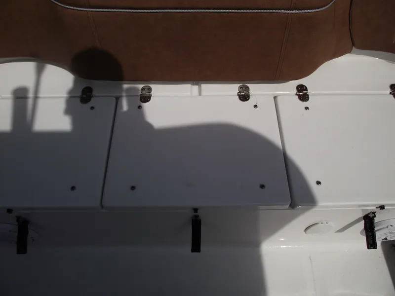 Slide: The Image of 2024 Sea Hunt Ultra 239 SE boat storage compartments with brown seating. - 44