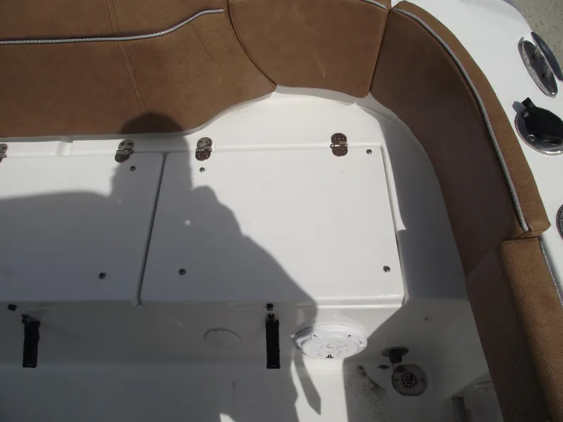 Slide: The Image of 2024 Sea Hunt Ultra 239 SE boat interior with brown seating and storage compartments. - 47