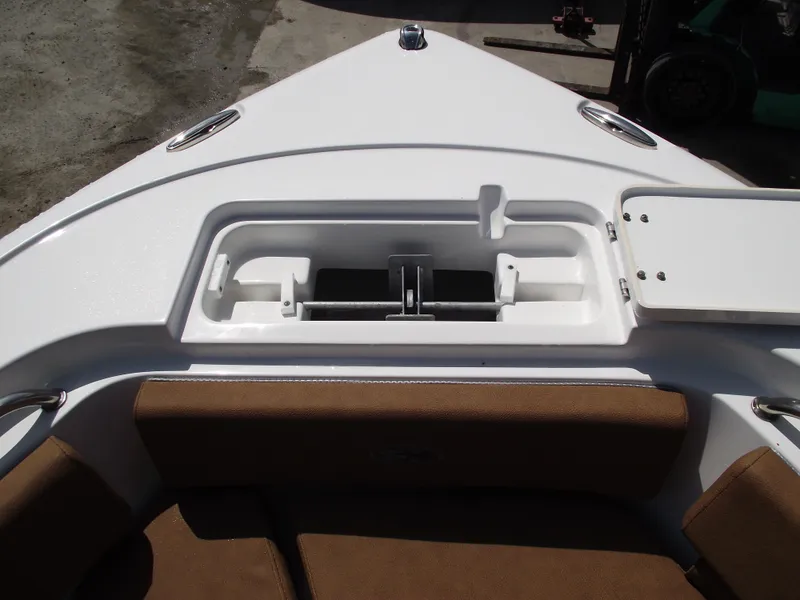 Slide: The Image of 2024 Sea Hunt Ultra 239 SE boat bow storage compartment with brown seating. - 6
