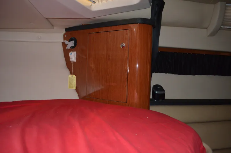 Slide: The Image of Interior cabin of 2008 Regal 3360 Window Express with wooden cabinet and red bedding. - 15