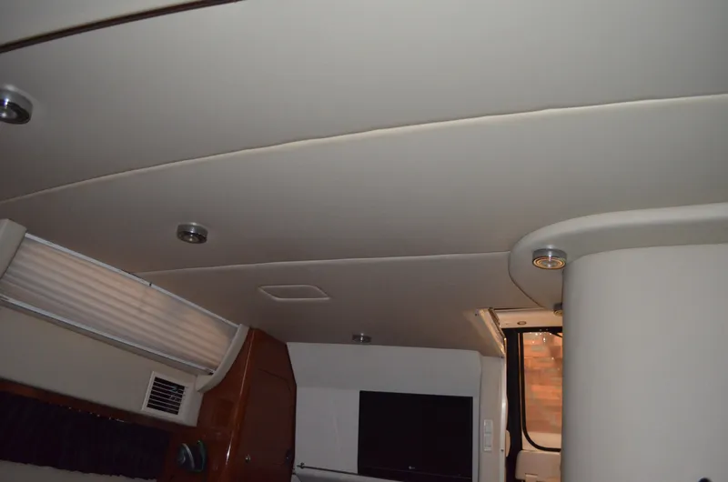 Slide: The Image of Interior of 2008 Regal 3360 Window Express boat, featuring ceiling and window details. - 16