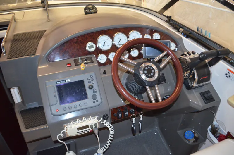 Slide: The Image of 2008 Regal 3360 Window Express boat dashboard with steering wheel and navigation controls. - 2