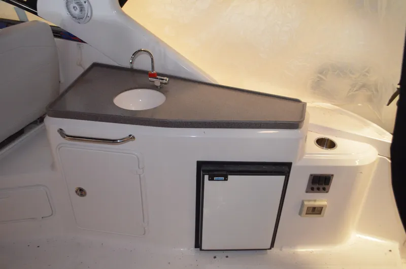 Slide: The Image of 2008 Regal 3360 Window Express boat kitchenette with sink, mini fridge, and storage. - 7